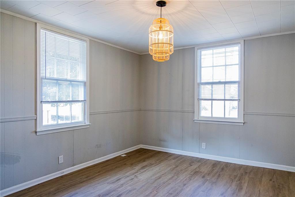 27 Oak Street Northeast Rome, GA 30161 - Photo 22 of 27 an empty room with wooden floor exposed radiator and windows