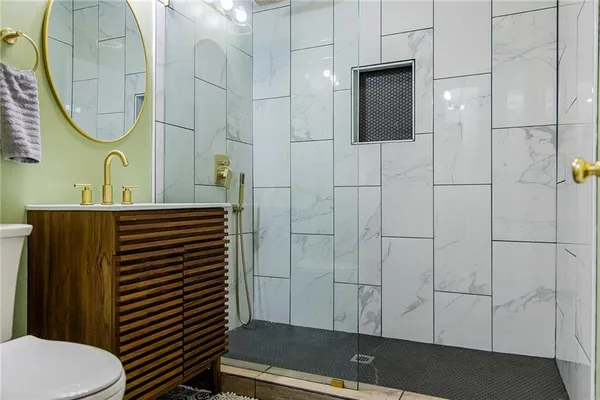 a bathroom with a sink a toilet and shower