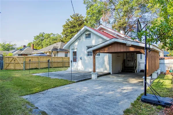 a view of a house with a yard and large tree