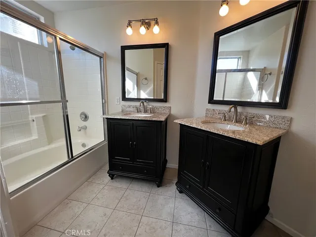 a bathroom with a double vanity sink and mirror
