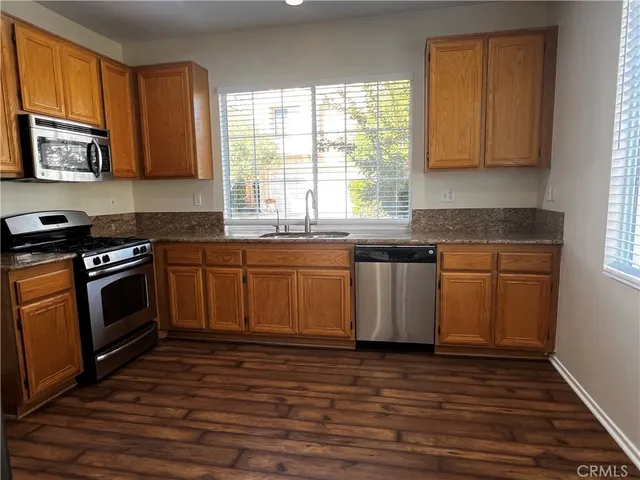 a kitchen with stainless steel appliances granite countertop a stove a sink and a microwave