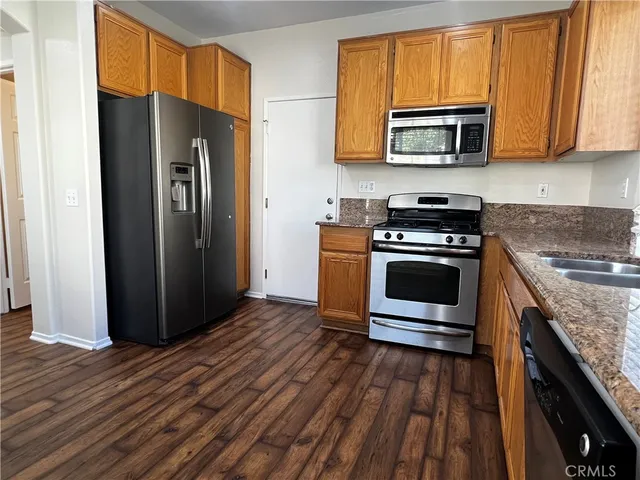 a kitchen with stainless steel appliances granite countertop a stove microwave and refrigerator
