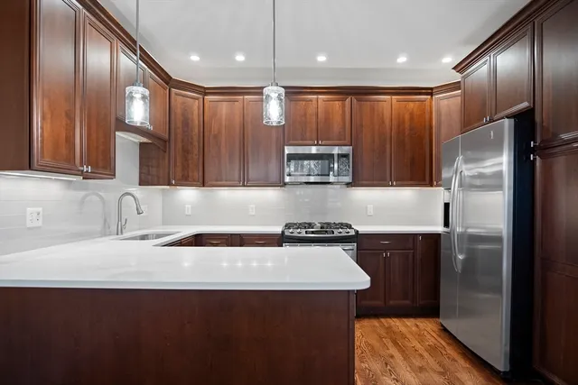 a kitchen with kitchen island granite countertop stainless steel appliances a sink stove and refrigerator