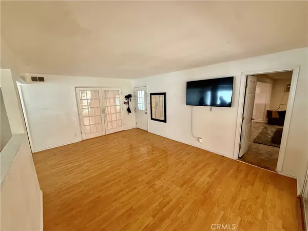 a view of a livingroom with wooden floor and a flat screen tv