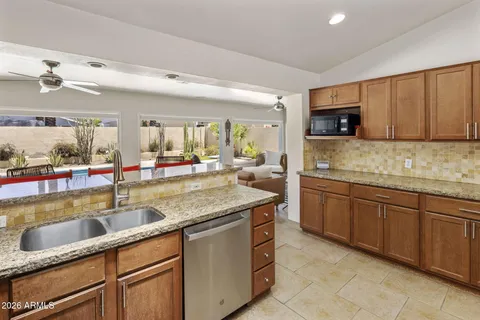 a kitchen with stainless steel appliances granite countertop a sink and a white cabinets