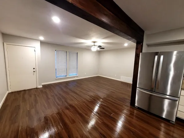 a view of an empty room with wooden floor