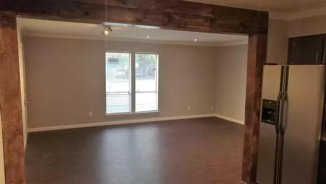 an empty room with wooden floor and a window