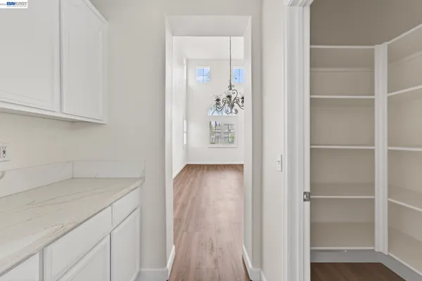 a view of a kitchen with wooden floor and electronic appliances