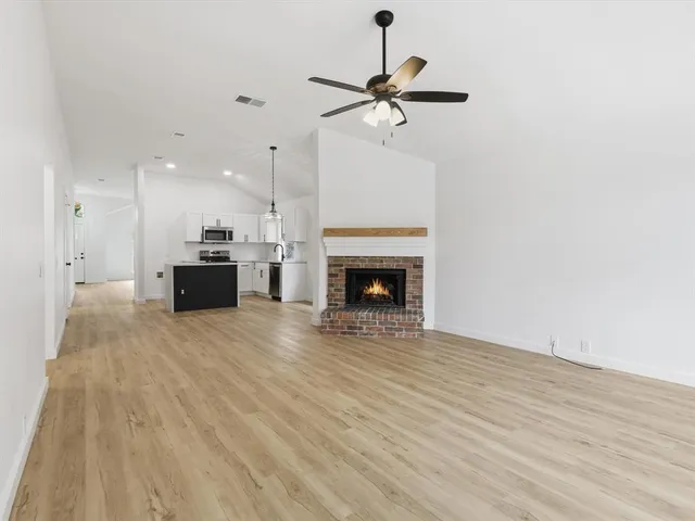 a view of an empty room with a window and fireplace