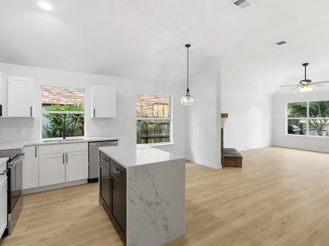 a open kitchen with stainless steel appliances granite countertop a sink stove and refrigerator