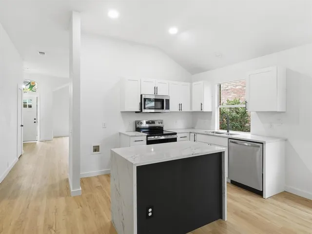 a kitchen with a sink a window and stainless steel appliances