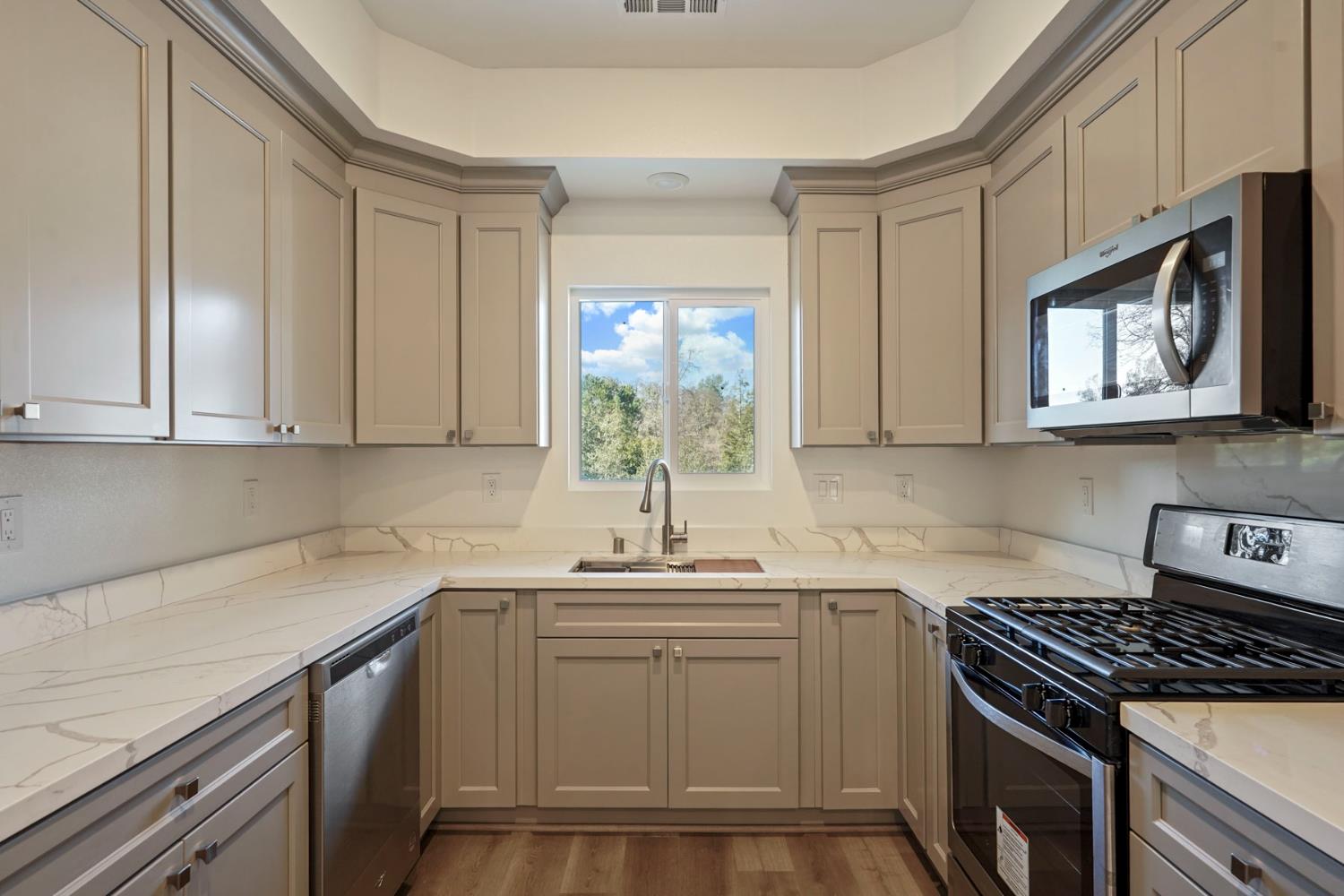 3286 Botfuher Road Valley Springs, CA 95252 - Photo 3 of 24 a kitchen with stainless steel appliances granite countertop white cabinets a window a sink and a stove