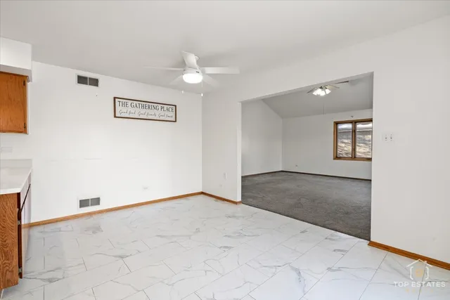 an empty room with windows and ceiling fan