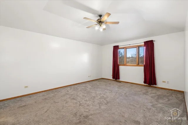 an empty room with a window and a ceiling fan