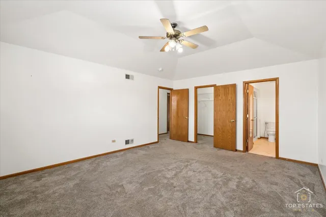 an empty room with chandelier fan
