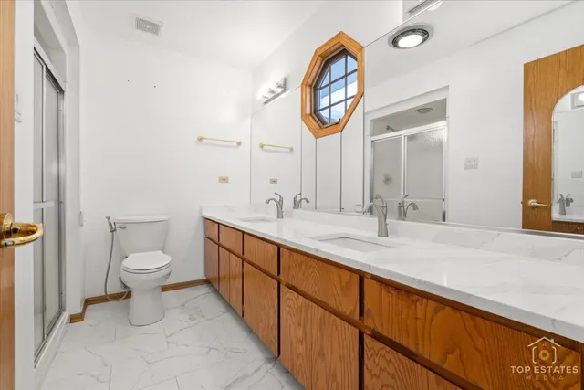 a spacious bathroom with a toilet a sink and a mirror
