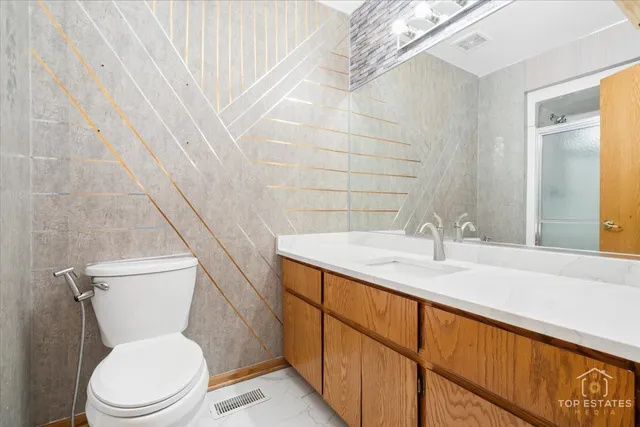 a bathroom with a granite countertop toilet sink and mirror