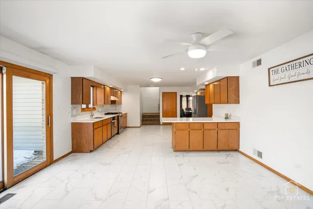 a large white kitchen with a large window a sink and a stove top oven