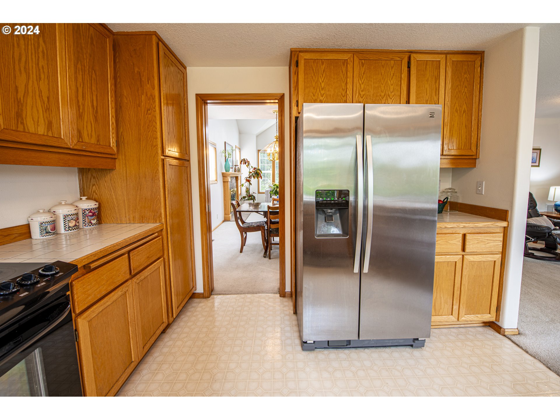 528 Granite Place Springfield, OR 97477 - Photo 12 of 38 a kitchen with stainless steel appliances granite countertop a refrigerator a stove and a sink with wooden floor