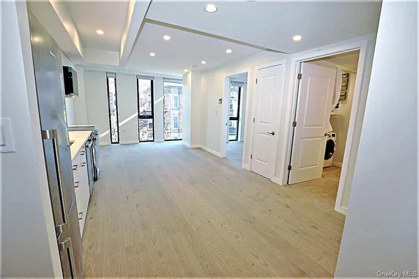 a view of livingroom with stainless steel appliances wooden floor