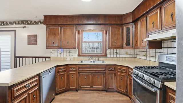 a kitchen with stainless steel appliances granite countertop a sink and cabinets