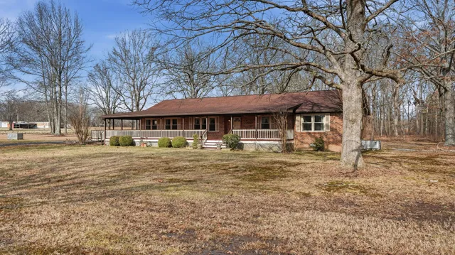 a view of a house with backyard and trees
