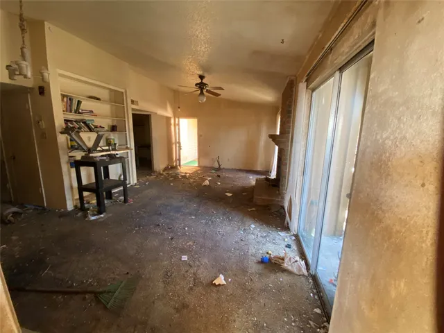 a view of a hallway to a livingroom with furniture and windows