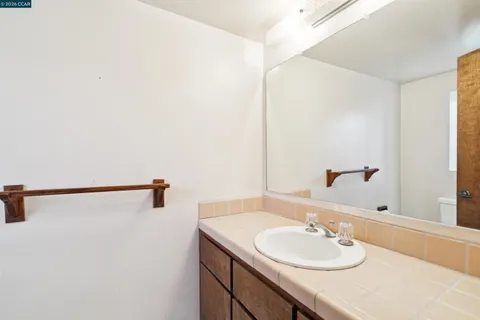 a bathroom with a granite countertop sink and a mirror