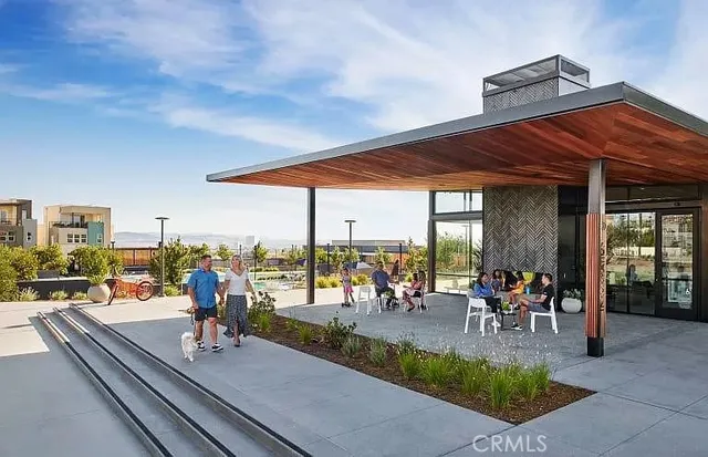 a view of a patio with a dining table and chairs under an umbrella with large trees