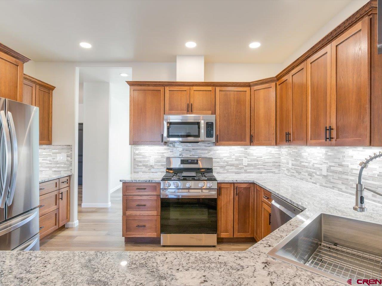 3415 Chestnut Drive Montrose, CO 81401 - Photo 11 of 28 a kitchen with stainless steel appliances granite countertop a stove a sink and a microwave