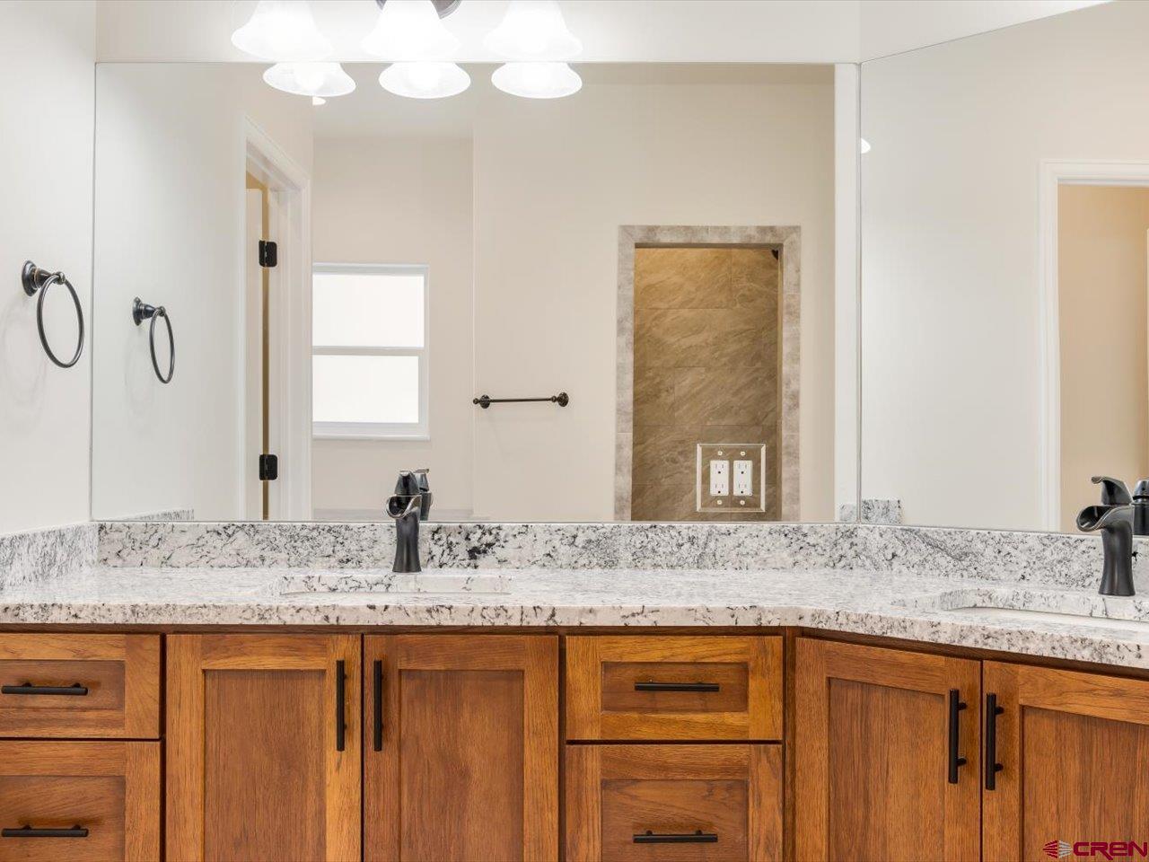 3415 Chestnut Drive Montrose, CO 81401 - Photo 18 of 28 a bathroom with a granite countertop sink and a mirror