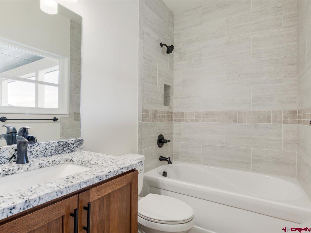 3415 Chestnut Drive Montrose, CO 81401 - Photo 21 of 28 a bathroom with a granite countertop sink a toilet and bathtub