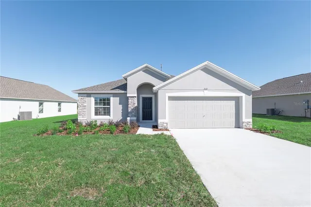 a front view of a house with a yard and garage
