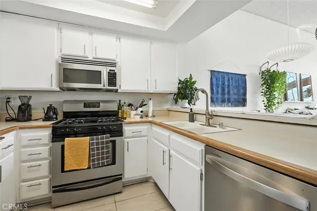 a kitchen with granite countertop a sink stove and microwave