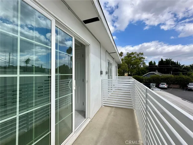 a view of a balcony with floor to ceiling windows and stairs