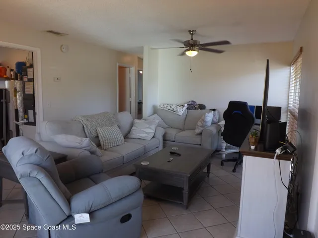 a living room with furniture and a ceiling fan
