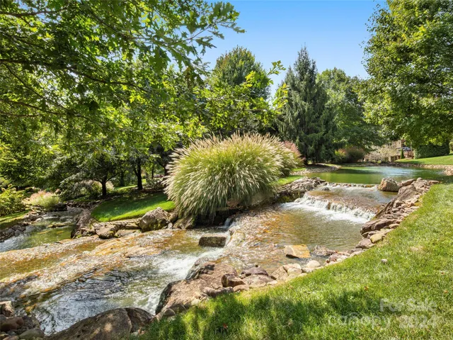 a front view of a house with a yard and potted plants