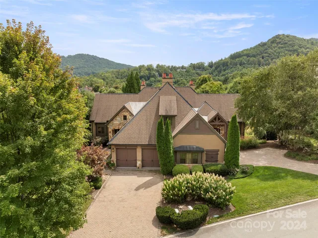 a view of a house with a small yard and potted plants