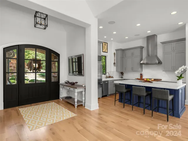 a living room with stainless steel appliances kitchen island granite countertop furniture wooden floor and a rug