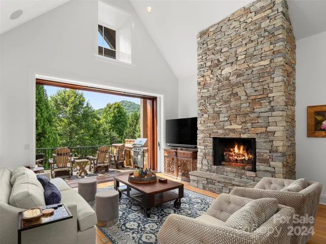 a living room with furniture fireplace and a large window