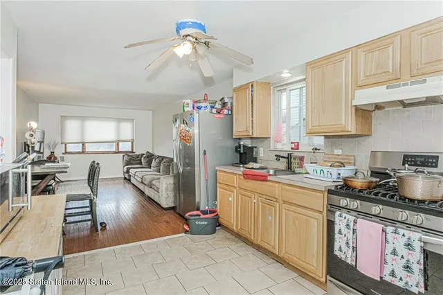 a kitchen with stainless steel appliances granite countertop a sink dishwasher stove refrigerator and cabinets