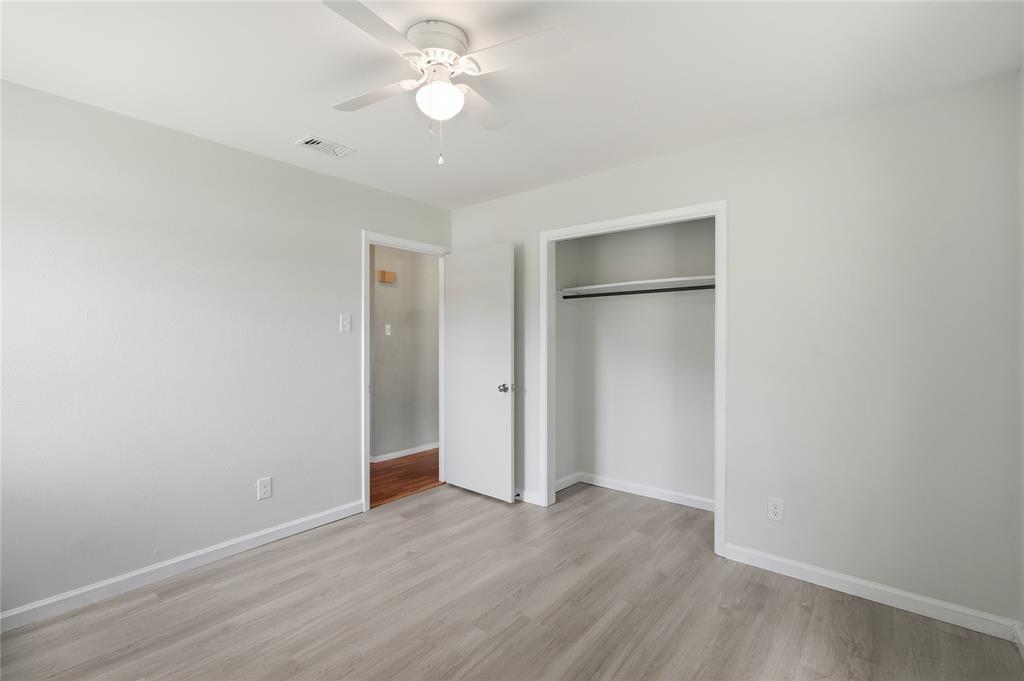 837 Springdale Road Bedford, TX 76021 - Photo 15 of 28 Bright room featuring light-toned walls, wood-finish flooring, a ceiling fan with integrated lighting, and an open closet with a hanging rod