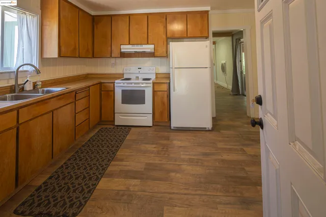 a kitchen with a refrigerator sink and cabinets