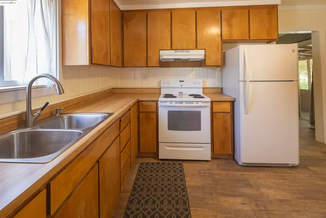 a kitchen with stainless steel appliances granite countertop a refrigerator sink and stove