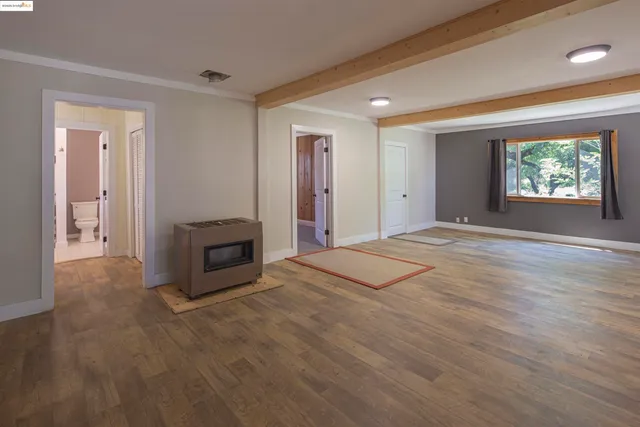 a view of an empty room with a fireplace and a window