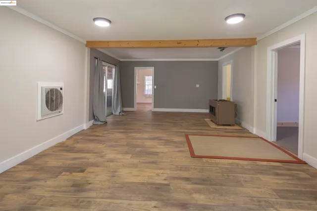 a view of a hallway with wooden floor and a bathroom