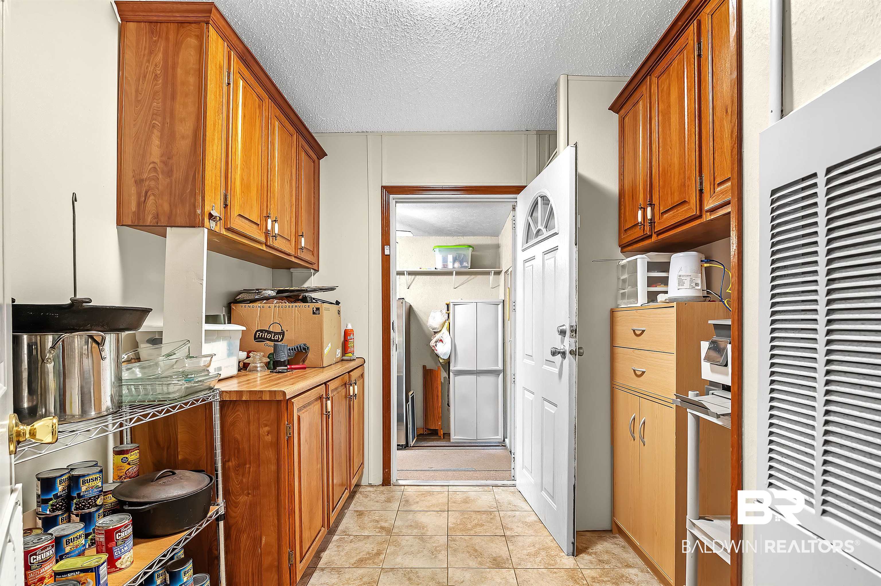10970 Stucki Road Elberta, AL 36530 - Photo 37 of 56 Kitchen with light tile patterned flooring, refrigerator, and a textured ceiling