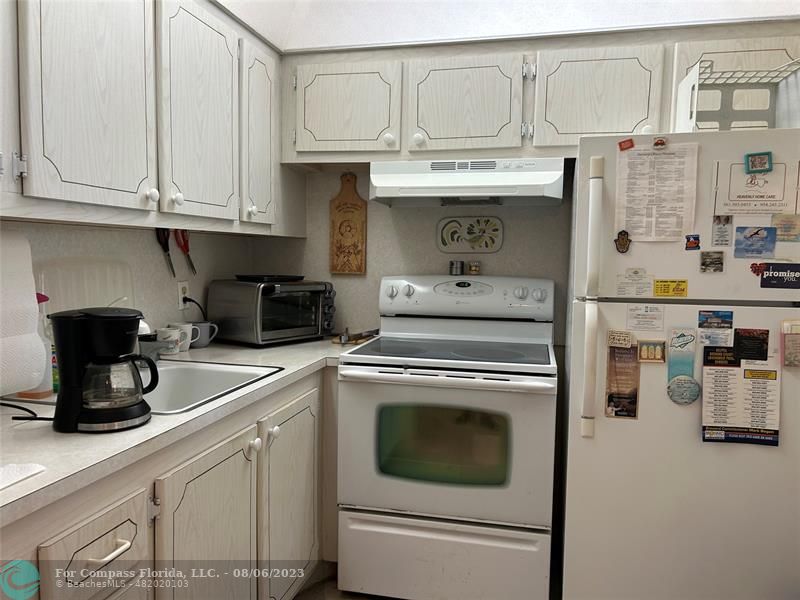 30 Tilford B, Unit 30 Deerfield Beach, FL 33442 - Photo 13 of 23 a kitchen with stainless steel appliances granite countertop a stove and a refrigerator