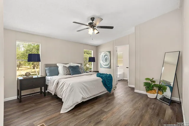 a bedroom with a bed chandelier and a window