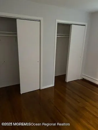 an empty room with wooden floor and closet